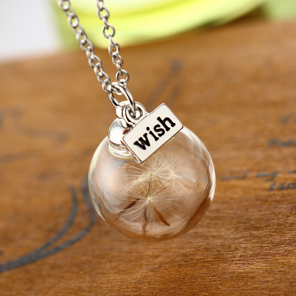 Close-up of dandelion detail inside round glass pendant
